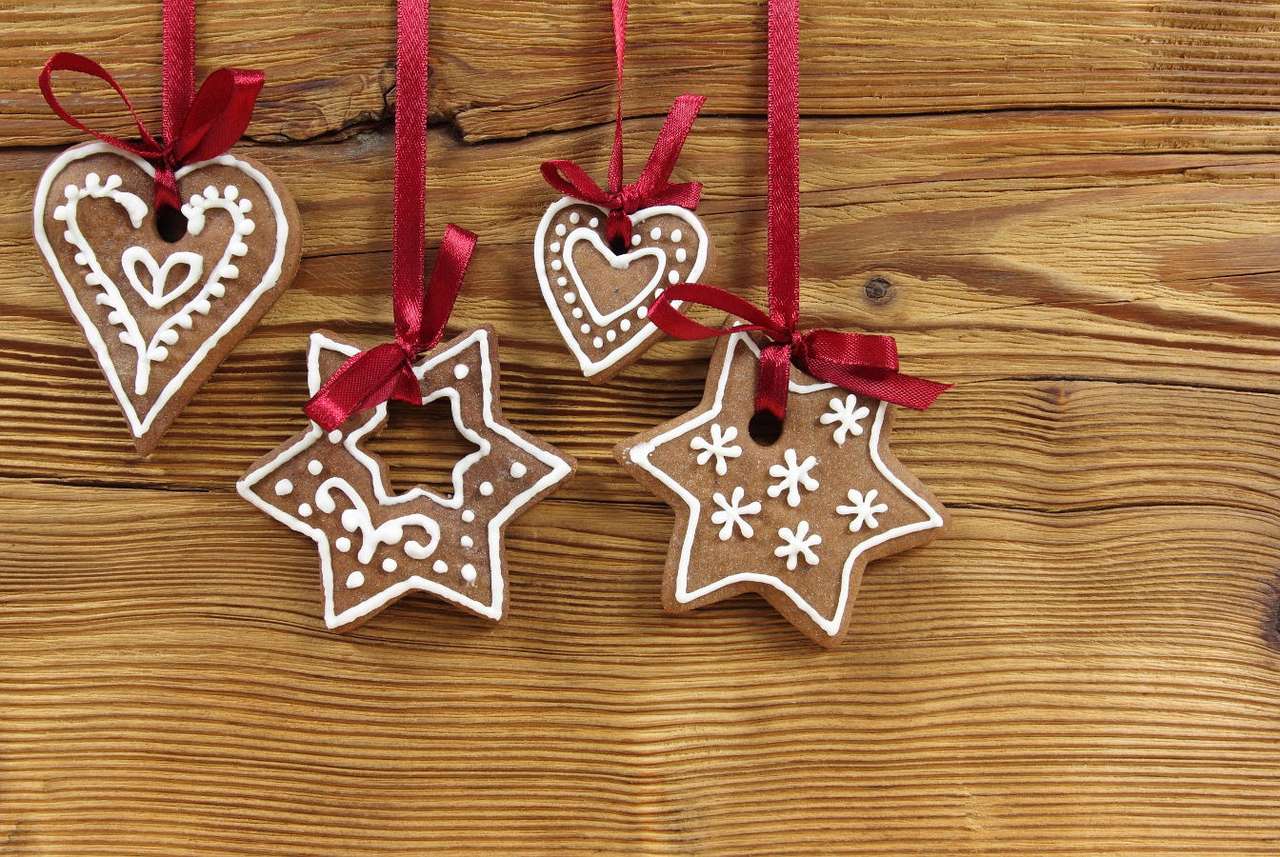 Χριστουγεννιάτικα μπισκότα μελοψωμάτων που κρέμονται σε κόκκινες κορδέλες παζλ online από φωτογραφία