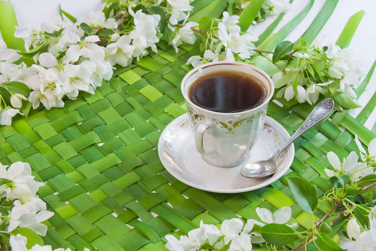 Cup of coffee with the sprigs of flowering apple-tree online puzzle