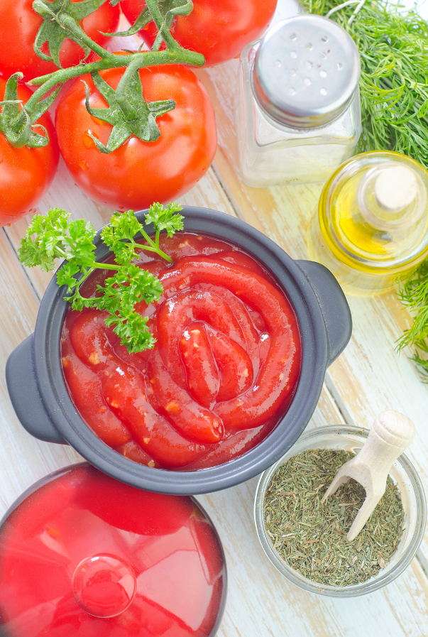 Tomato sauce surrounded by spices, oil and tomatoes online puzzle