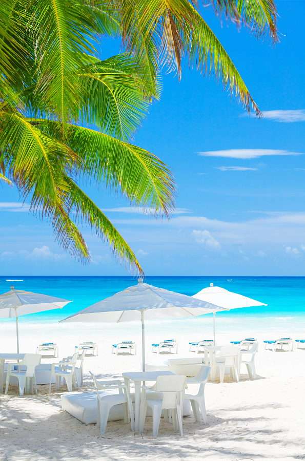 Stoly pod slunečníkem na tropické pláži puzzle online z fotografie