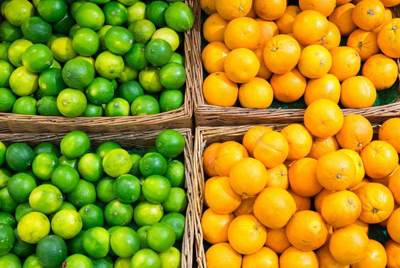 Limes and oranges in baskets at a market stall puzzle online from photo