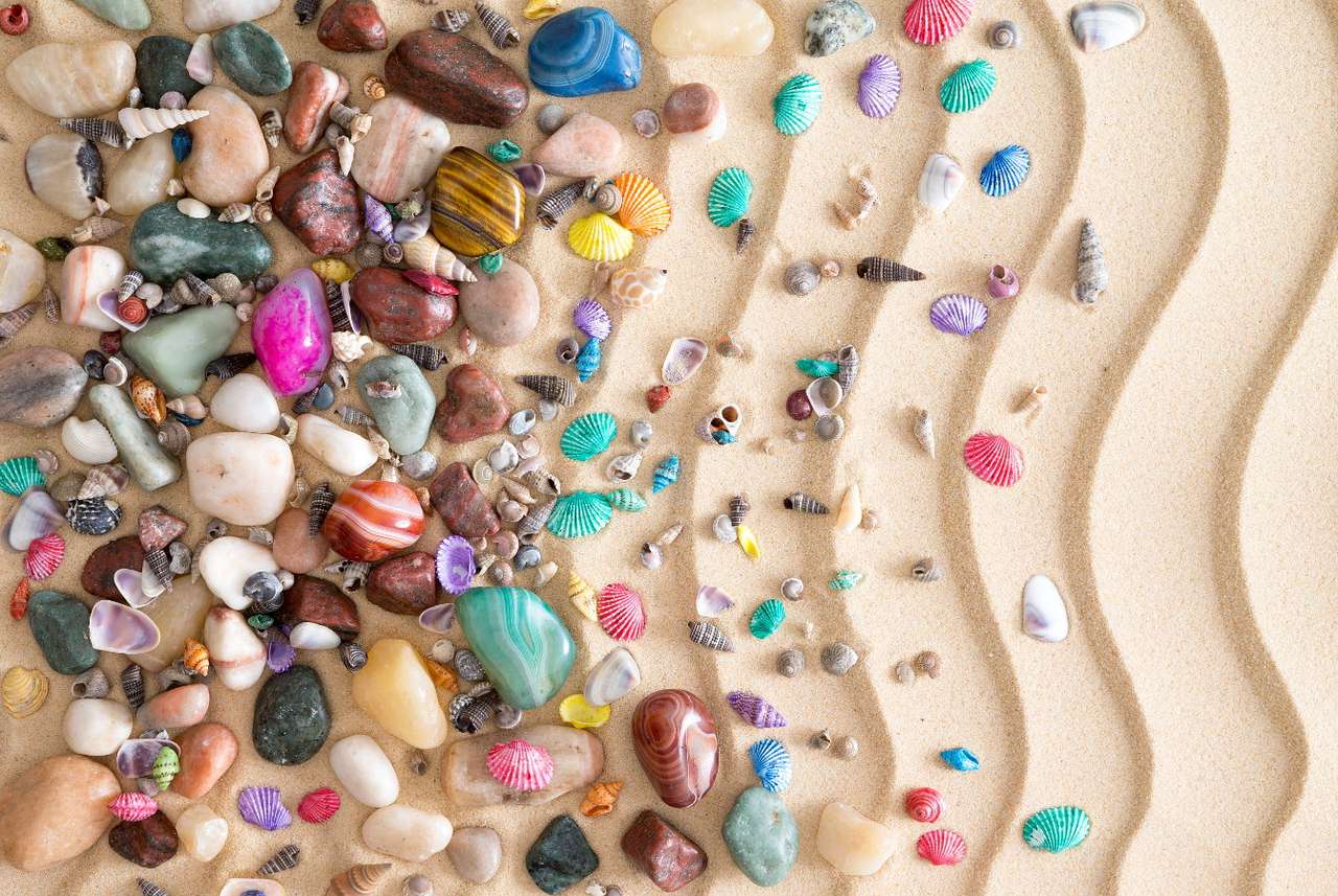 Χρωματιστά βότσαλα και κοχύλια στην άμμο που σχηματίζονται από κύματα παζλ online από φωτογραφία