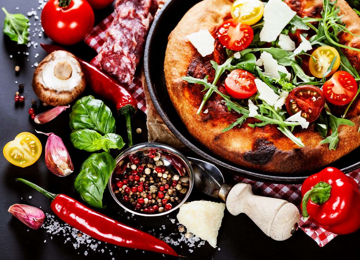 Пица и пресни зеленчуци на черна маса онлайн пъзел от снимка