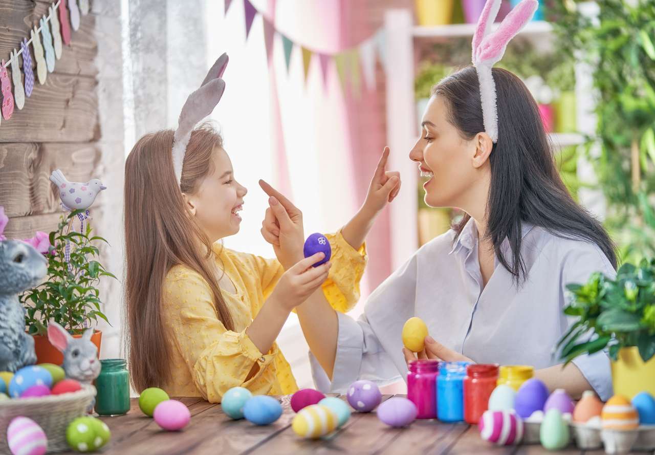 Mother with a child paints Easter eggs puzzle online from photo