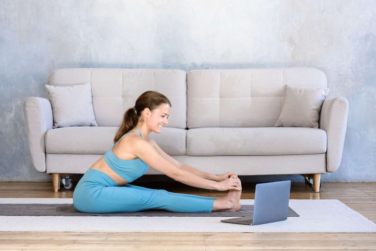 Yoga frente a una computadora portátil rompecabezas en línea