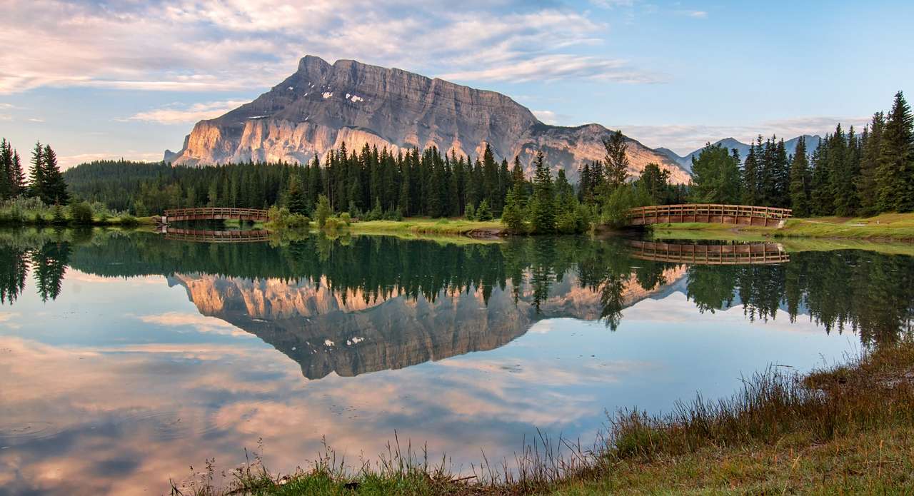 Rundle Mountain reflekteras i damm med två broar Pussel online