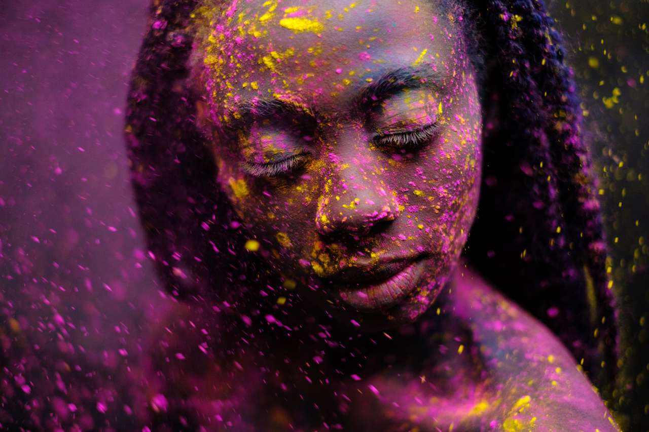 Mujer africana con polvos de colores en el rostro y el cuerpo. rompecabezas en línea