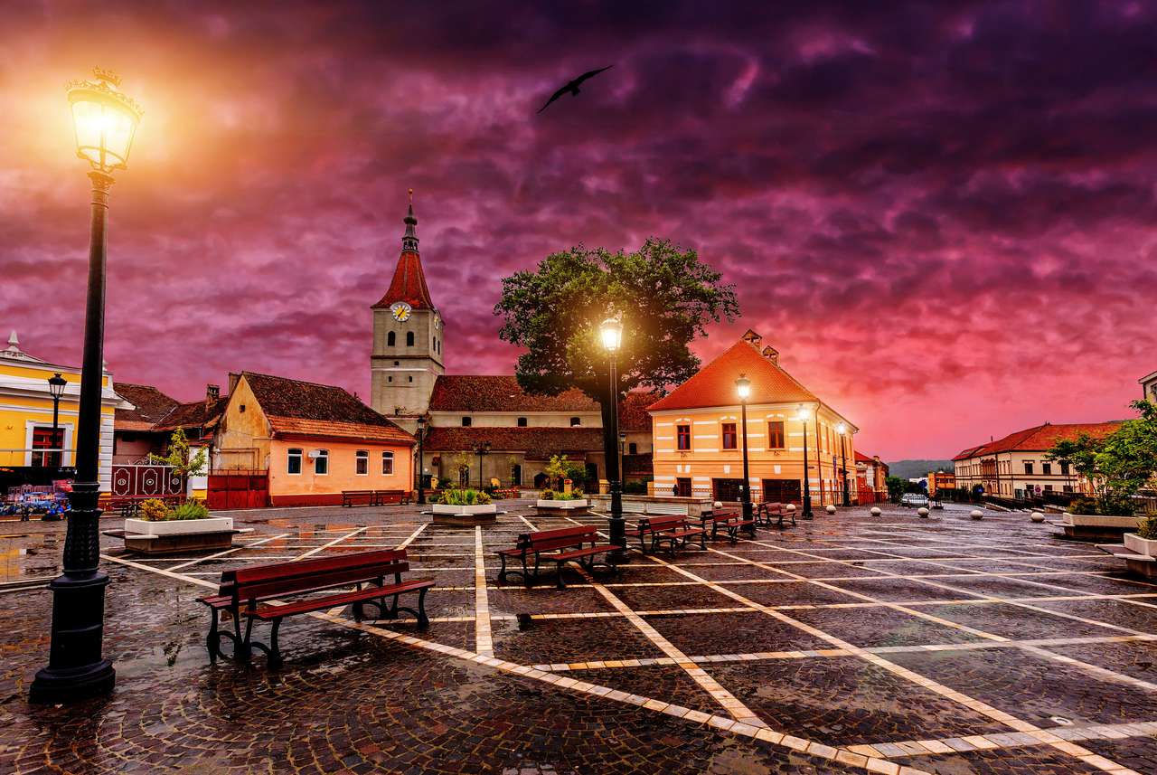 Een zonsondergang boven het middeleeuwse raadshuis in Brasov puzzel online van foto